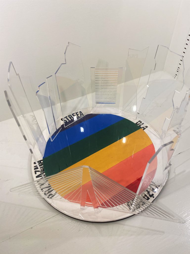 Sculpture artwork with rainbow in center and glass around the perimeter.